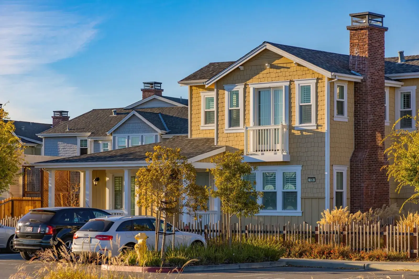 A picturesque suburban house with cars parked, the kind of home we buy in Hufsmith