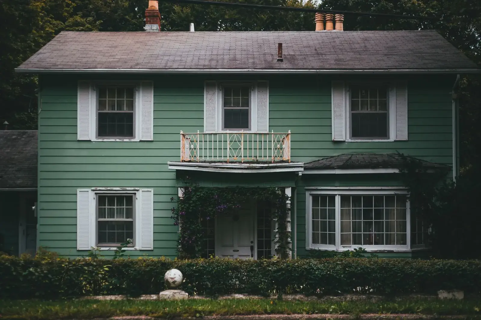 A picturesque green wooden house, the kind of home we buy in Imperial Oaks