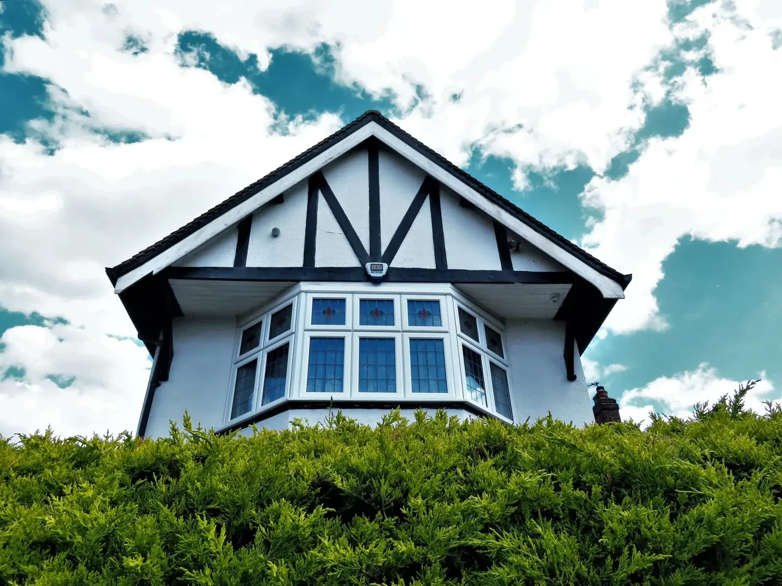 Tudor-style house facade with a bay, the kind of home we buy in Oyster Creek
