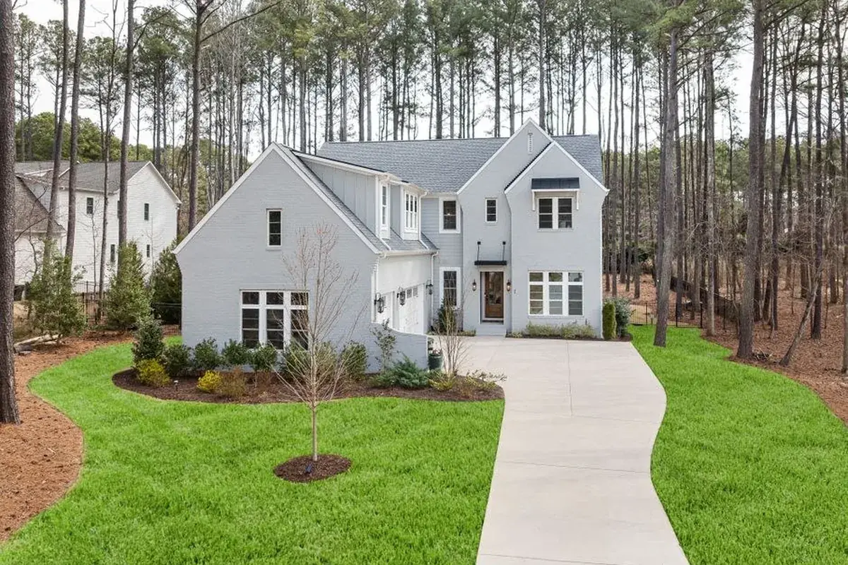 Elegant suburban home with gray siding, the kind of home we buy in Roman Forest